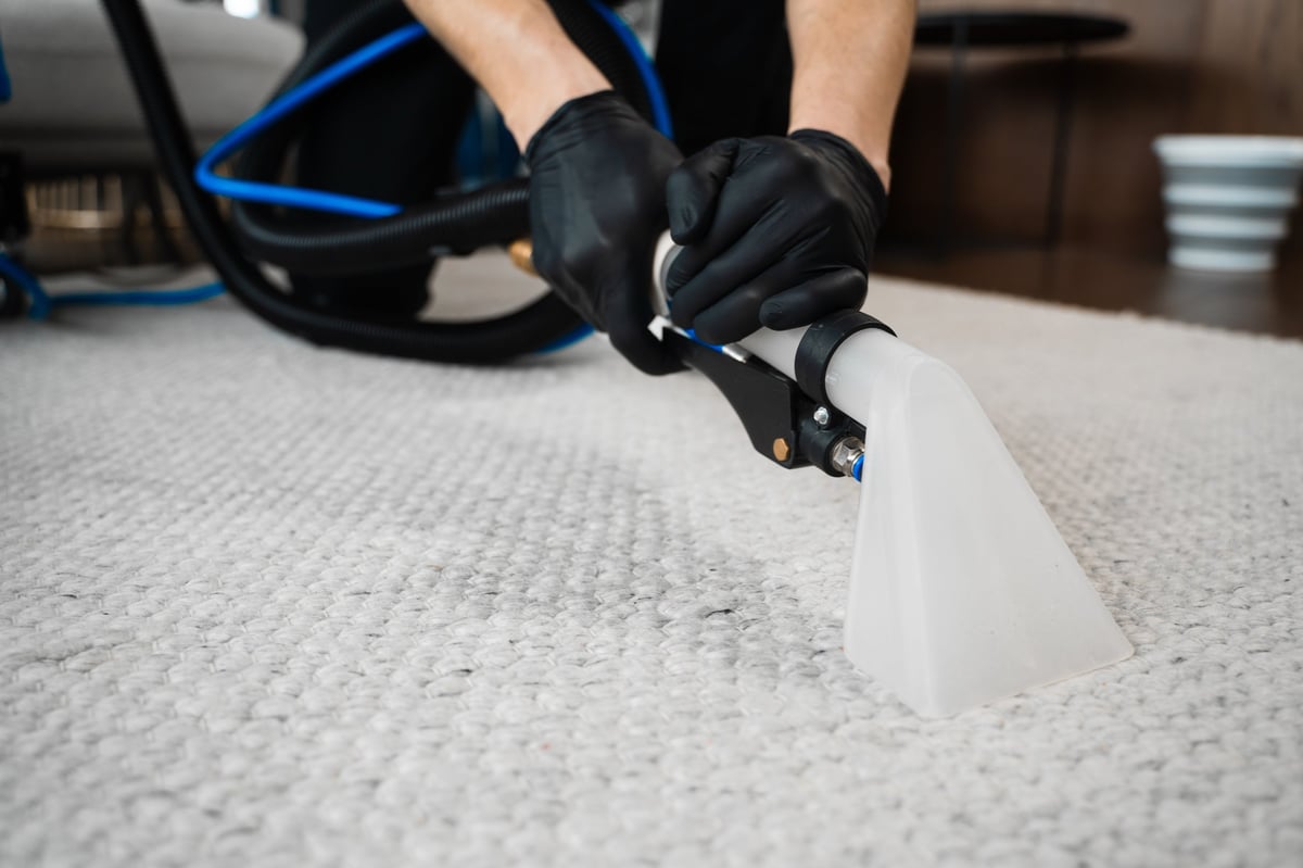 Extractor machine washing dust and stains out of a carpet