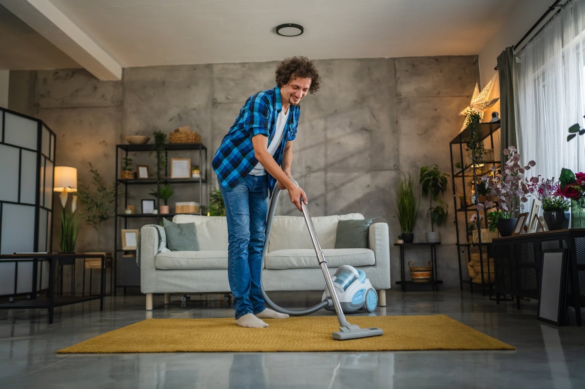 Man vacuuming the living room carpet